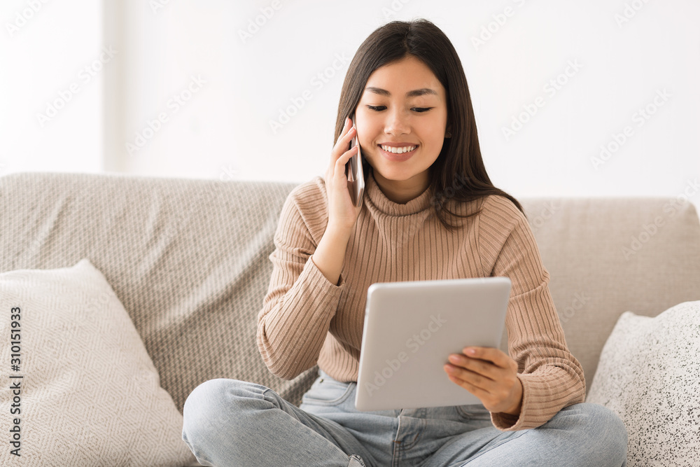 Girl multitasking, uing tablet and talking on phone Girl multitasking, uing tablet and talking on phone