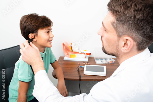 Audiologist check a child's ears.Mixed race boy having hearing test , procedure impedance audiometry