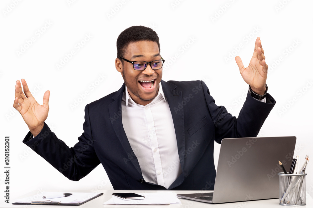 Excited black manager celebrating his victory at work Excited black manager celebrating his victory at work
