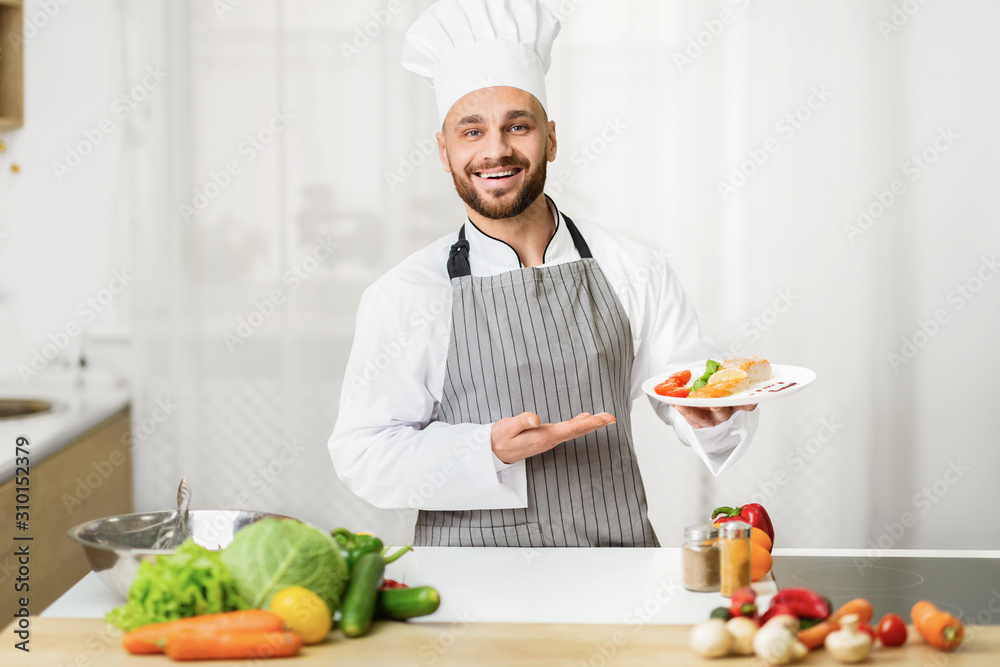 Chef Man Holding Plate Presenting Dish Standing In Kitchen Indoor Chef Man Holding Plate Presenting Dish Standing In Kitchen Indoor