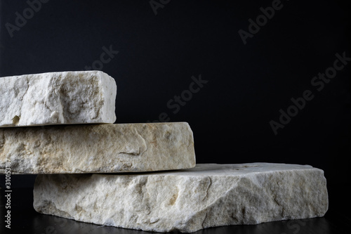3 white marble rough stones on a black background
