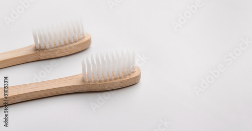 Close up of two bamboo toothbrushes on white background