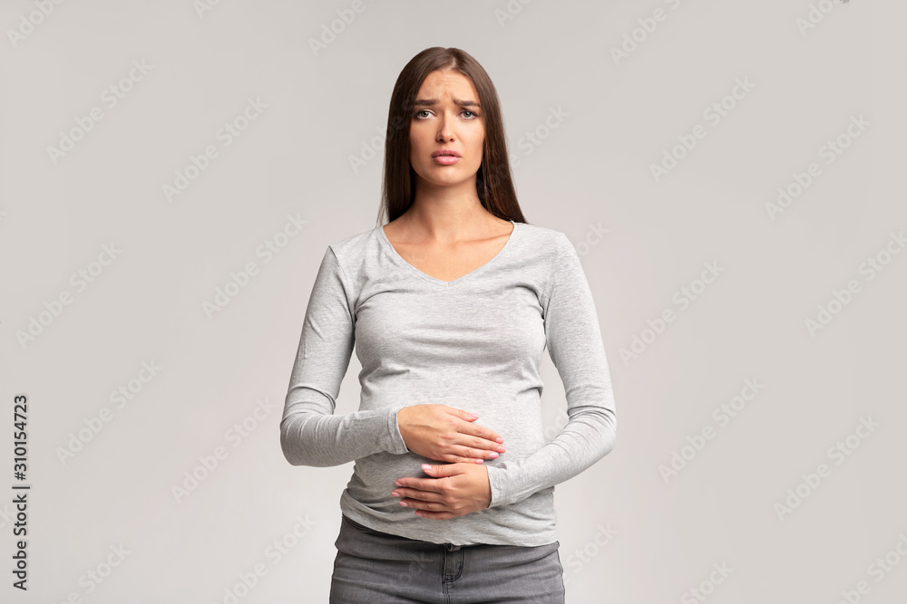Sad Pregnant Woman Touching Belly Standing, Studio Shot Sad Pregnant Woman Touching Belly Standing, Studio Shot