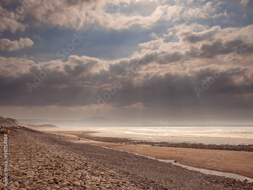 Empty Strandhill beach  county Sligo  Ireland  Dramatic cloudy sky with sun rays  Warm and cool tones 