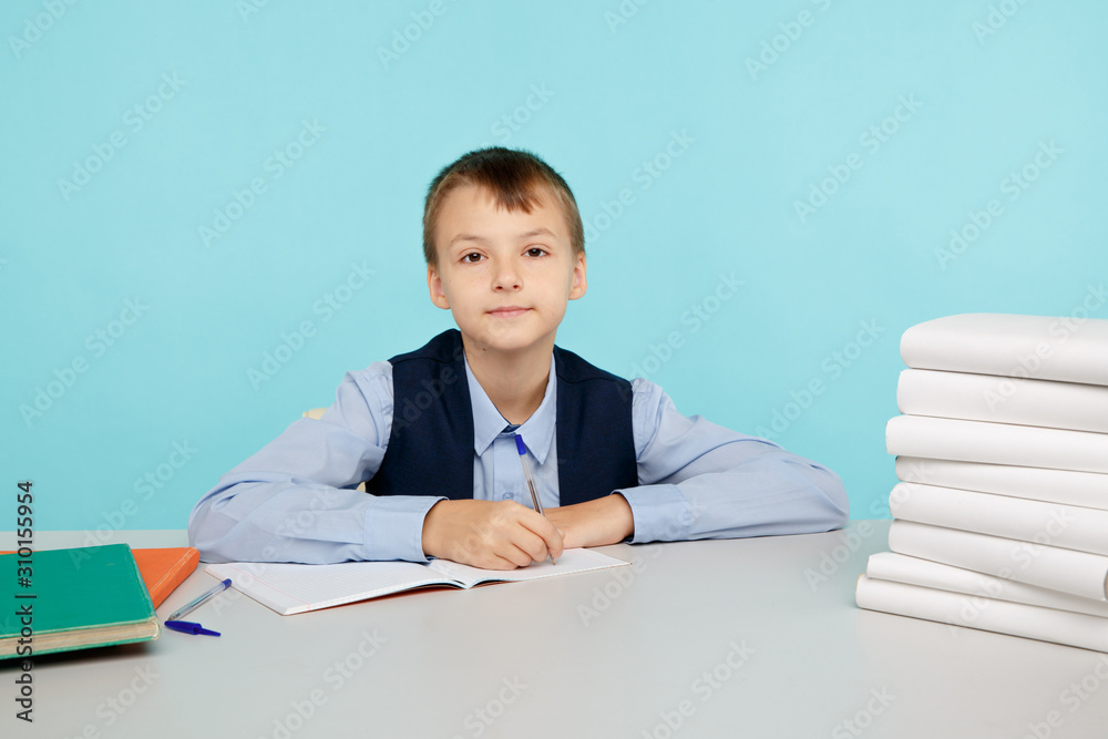 Education a school concept. Boy sitting at the table and studying isolated
