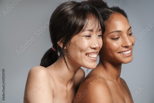 Portrait of two multinational half-naked women hugging and laughing