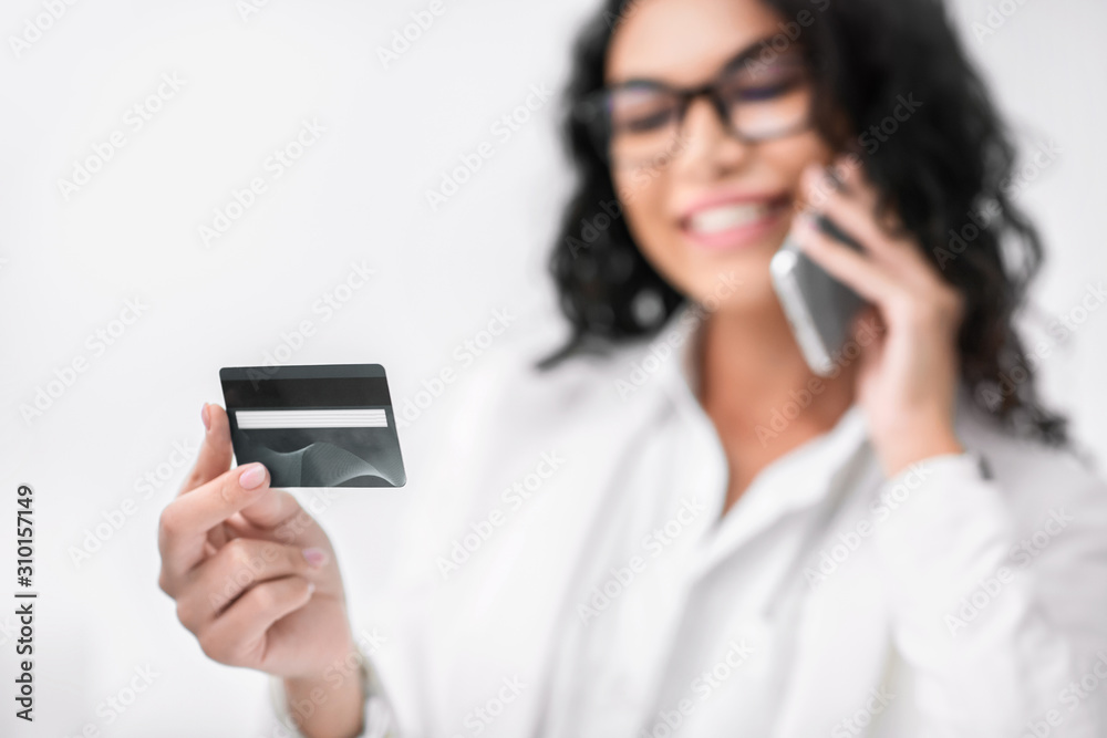 Smiling mexican woman holding credit card talking on phone Smiling mexican woman holding credit card talking on phone