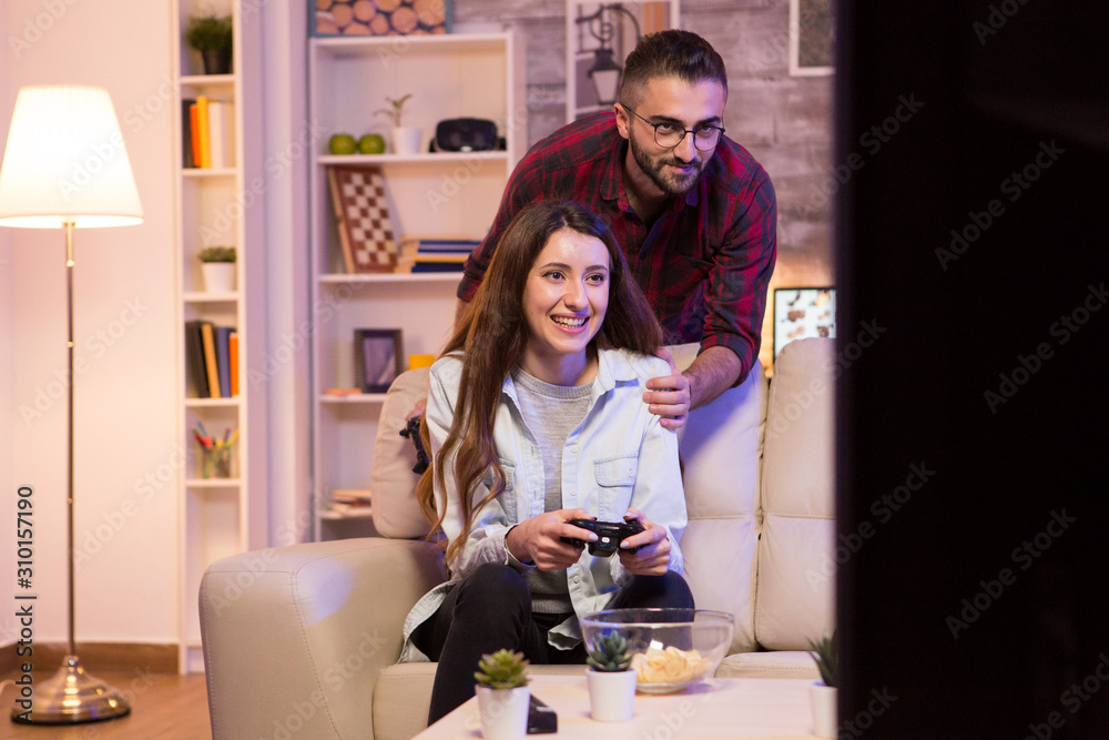 Photo of young couple playing video games on television