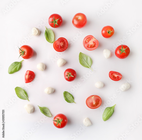 Rpe red cherry tomatos and mozzarella on white background.