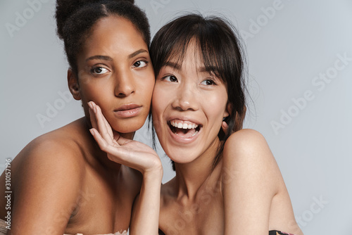 Portrait of two multinational women posing together and smiling