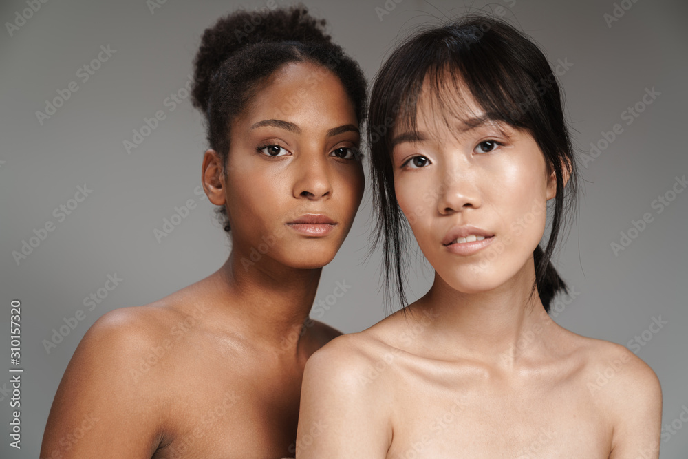 Portrait of two multinational women posing and looking at camera Portrait of two multinational women posing and looking at camera