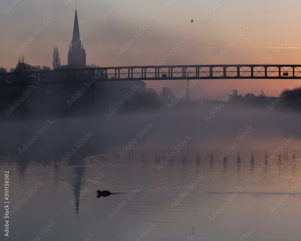 Naklejka premium An atmospheric sunrise on the banks of the Leie in Wervik, Belgium.