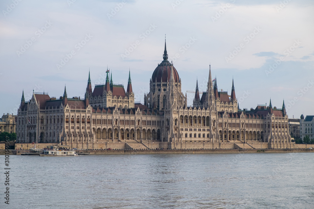 View of historical building of Hungarian Parliament on Danube river in Budapest, Hungary, Europe.