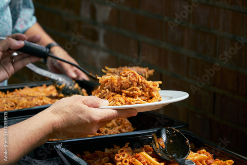 Macaroni and tomato sauce ready to serve. Image of prepared catering food at the time of serving the dishes