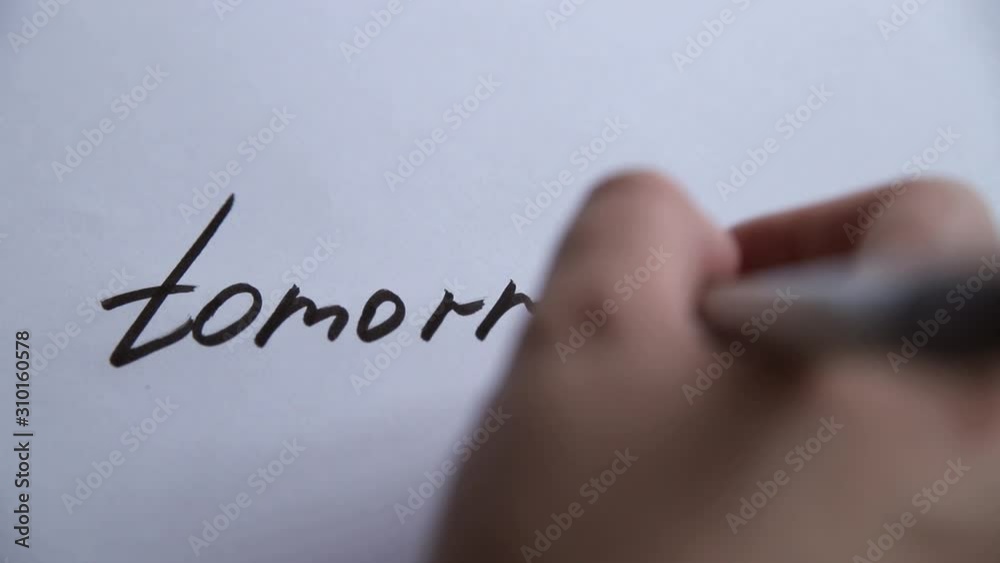 Hand writing Tomorrow on white paper