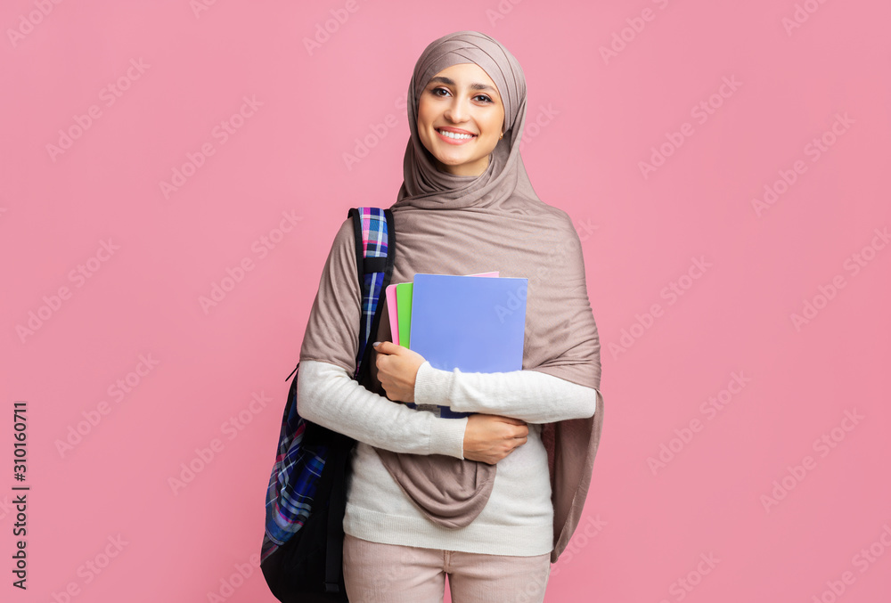 Portrait of happy muslim woman in hijab with notepads and backpack Portrait of happy muslim woman in hijab with notepads and backpack