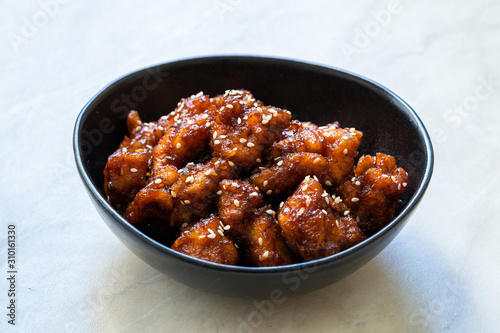 Asian Food Homemade Chinese General Tsos Chicken with Sesame Seeds served with Chopsticks.