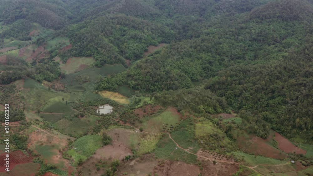 Aerial shot - flyover and tilt and pan over farmland, countryside, jungle and mountainside - Northern Thailand. Aerial shot - flyover and tilt and pan over farmland, countryside, jungle and mountainside - Northern Thailand.