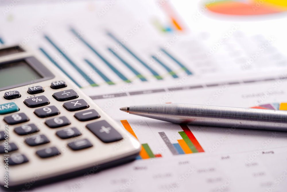 Obraz premium Calculator and pen on charts and graphs spreadsheet paper. Finance, Account, Statistics, Analytic research data and Business company meeting concept.