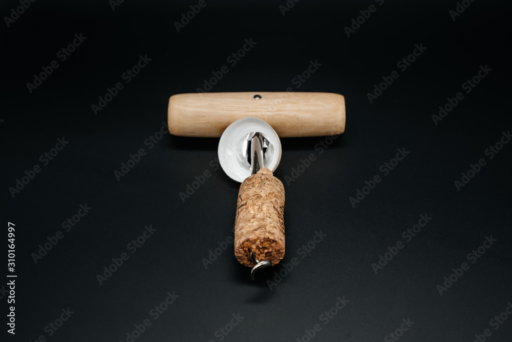 Corkscrew with cork on dark background close up