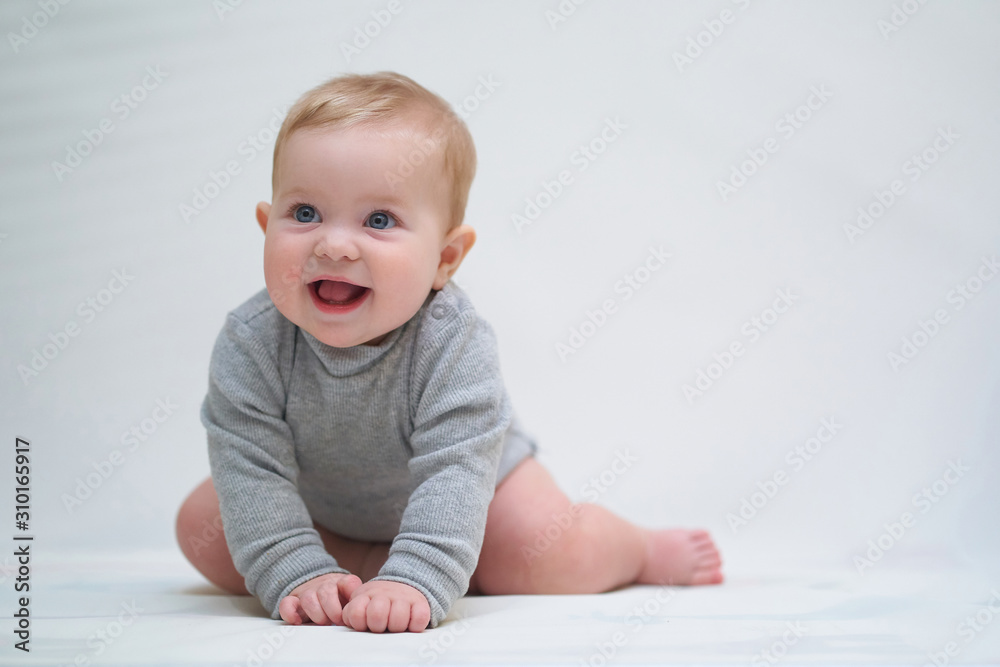 a six-month-old baby learns to crawl. emotional portrait of a child a six-month-old baby learns to crawl. emotional portrait of a child