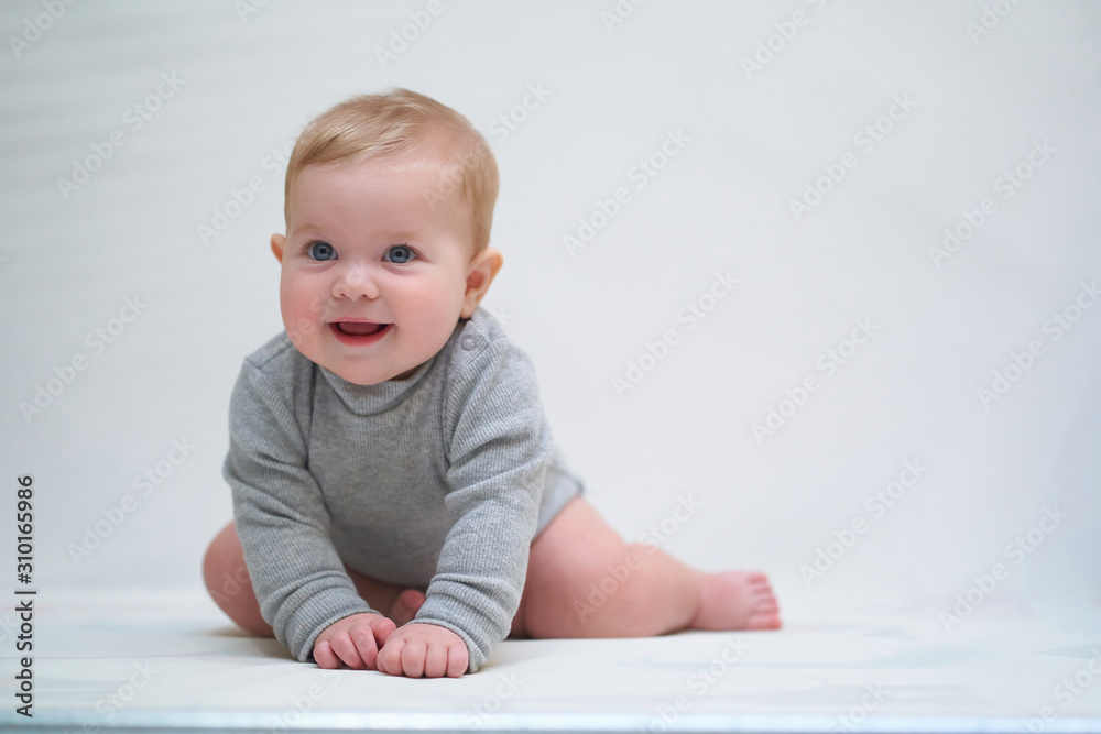 a six-month-old baby learns to crawl. emotional portrait of a child a six-month-old baby learns to crawl. emotional portrait of a child
