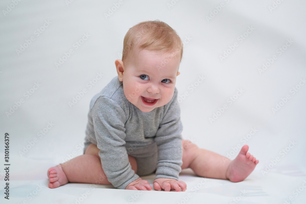 a six-month-old baby learns to crawl. emotional portrait of a child a six-month-old baby learns to crawl. emotional portrait of a child