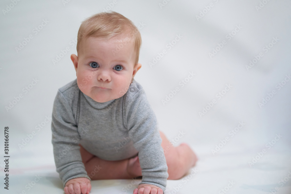 a six-month-old baby learns to crawl. emotional portrait of a child a six-month-old baby learns to crawl. emotional portrait of a child