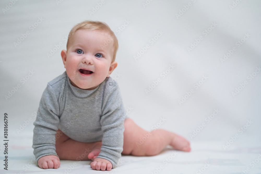 a six-month-old baby learns to crawl. emotional portrait of a child a six-month-old baby learns to crawl. emotional portrait of a child