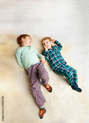 children play on the floor. in pajamas in the morning after sleep.