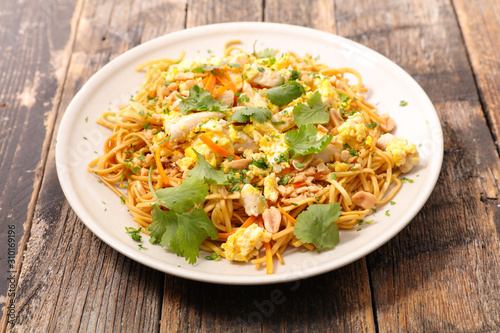 fried noodles with fried egg, peanut, vegetable and coriander