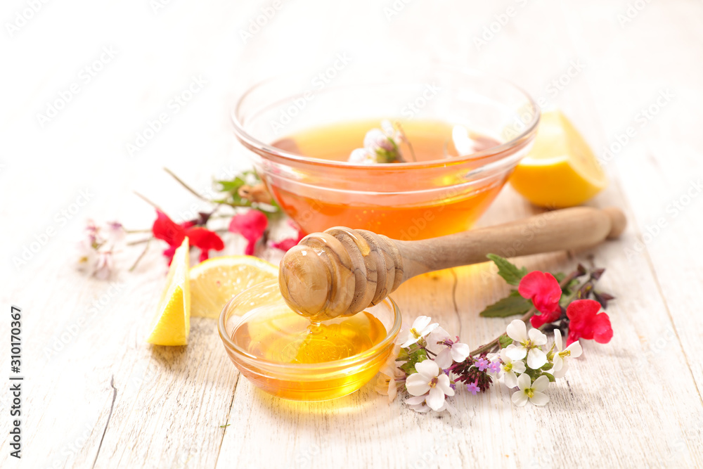 bowl of floral honey with lemon and flowers bowl of floral honey with lemon and flowers