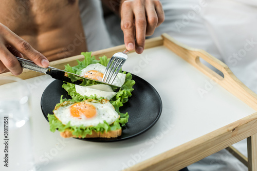 cropped view of bi-racial man having breakfast in morning