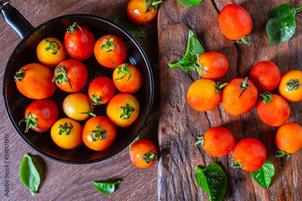 Fresh tomatoes in a pan on a wooden background. Fresh tomatoes in a pan on a wooden background.