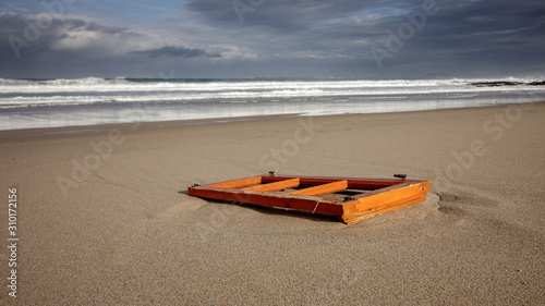 Remains of beach front shack washed up on a beach in Barranan Galicia Spain photo