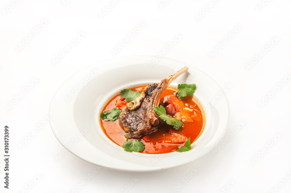Vegetable soup with tomatoes in a restaurant close-up. Lamb soup on bone noodles on a white plate and copy space. Vegetable soup with tomatoes in a restaurant close-up. Lamb soup on bone noodles on a white plate and copy space.