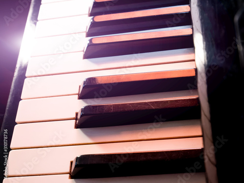 Old retro piano keys. close up view. Black and white keys, octave. Lighting effect