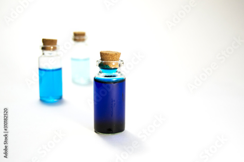 Three glass jars with blue liquid. The concept of medicine, beauty and health.