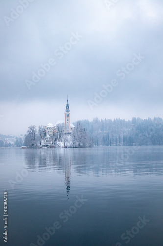 Lake Bled in winter season with snow and tourist boats
