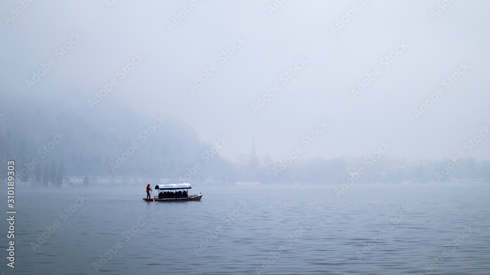 Naklejka premium Isolated boats on Lake Bled in winter with a blanding background