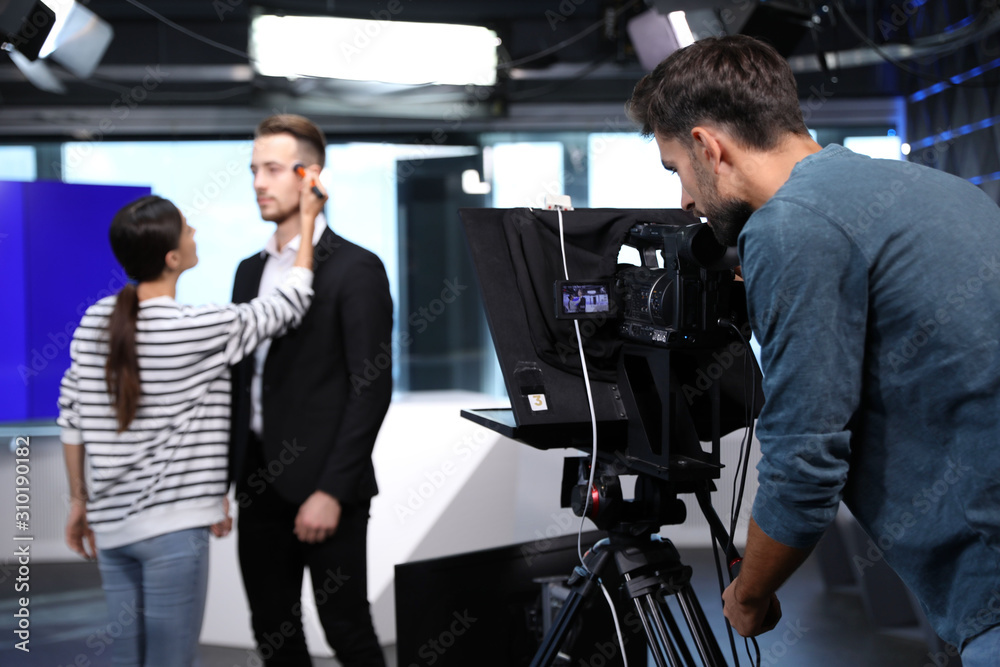 Presenter, makeup artist and video camera operator working in studio. News broadcasting Presenter, makeup artist and video camera operator working in studio. News broadcasting