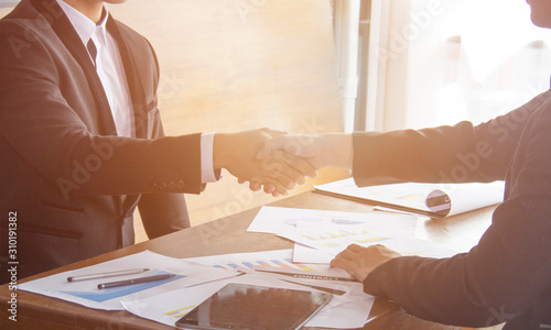 Two confident business man shaking hands during a meeting in the office, success, dealing, greeting and partner concept or team work handshake after meeting completion