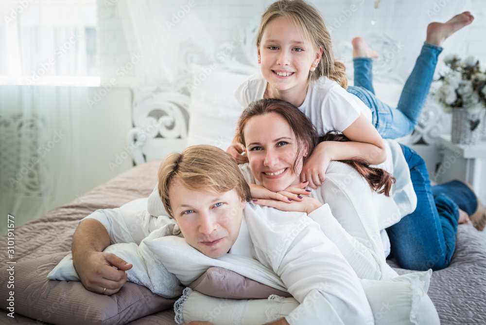 Beautiful positive family mom dad and older daughter and newborn brother in a beautiful and stylish room. Perfect family concept. Advertising concept Beautiful positive family mom dad and older daughter and newborn brother in a beautiful and stylish room. Perfect family concept. Advertising concept