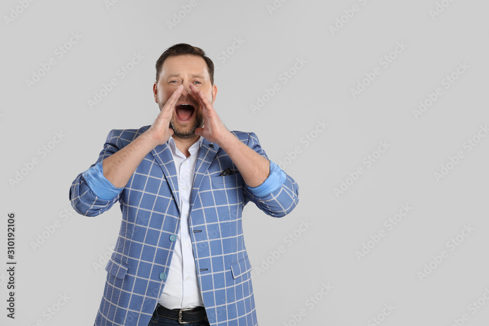 Portrait of screaming mature man on light grey background Portrait of screaming mature man on light grey background