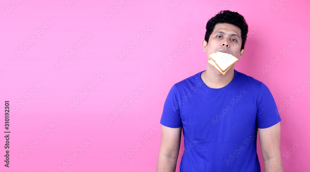 Asia Men feel bored with bread on pink background in studio With copy space. Asia Men feel bored with bread on pink background in studio With copy space.
