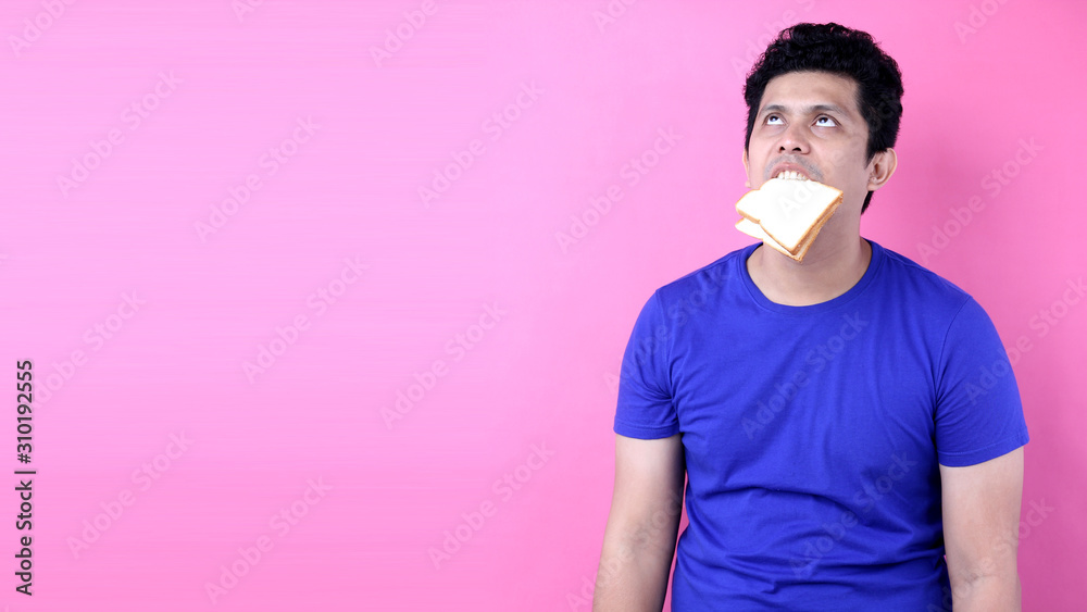 Asia Men feel bored with bread on pink background in studio With copy space. Asia Men feel bored with bread on pink background in studio With copy space.