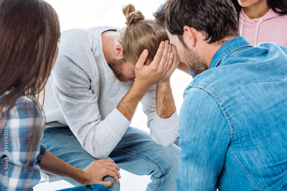 support group helping stressed man on chair isolated on white support group helping stressed man on chair isolated on white