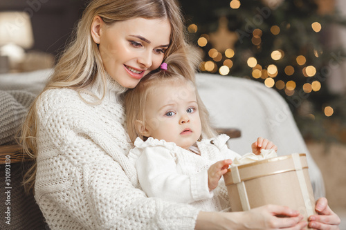 Photography Young attractive blond mother with her little daughter at Christmas time