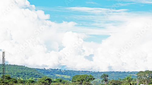 Blue sky landscape with clouds  a mountain and trees