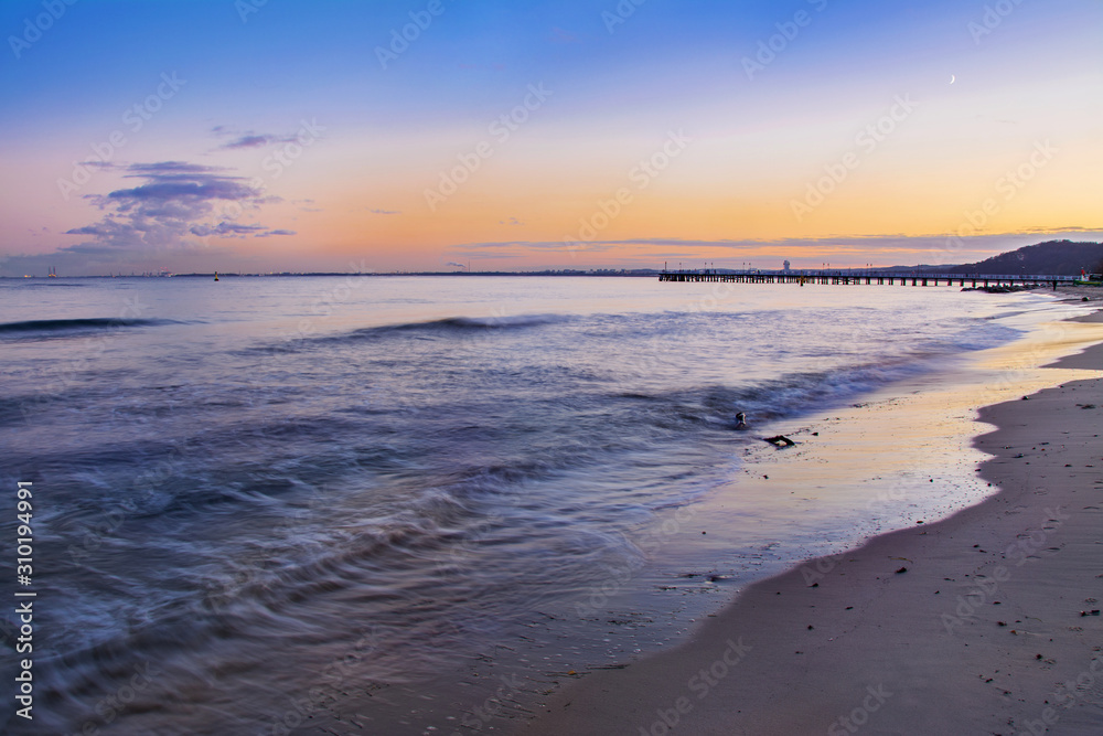 A beautiful sunset over the Baltic Sea, in the distance a pier in Gdynia. Poland